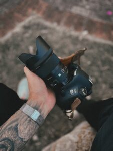 fotografía de una mano sosteniendo una cámara réflex