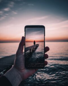 fotografía de un celular tomando una foto de un paisaje