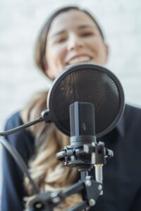 Mujer sonríe frente al micrófono 